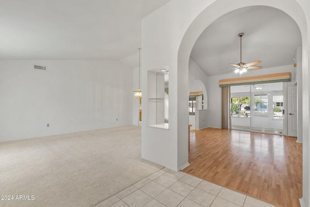 spare room featuring ceiling fan, light tile patterned floors, and vaulted ceiling