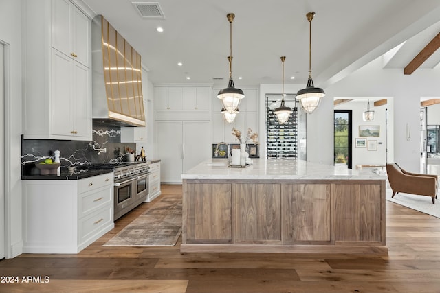 kitchen with a large island, double oven range, and white cabinetry