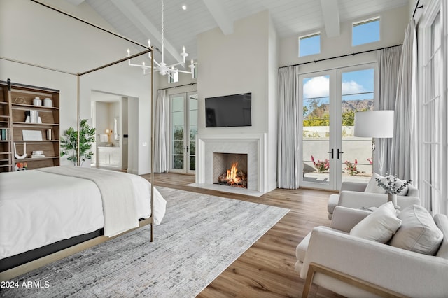 bedroom with french doors, an inviting chandelier, beamed ceiling, wood-type flooring, and access to outside