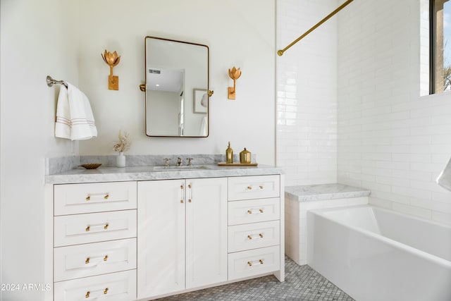 bathroom with tile patterned floors, a bathtub, and vanity