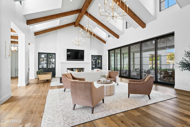 living room with beam ceiling, hardwood / wood-style floors, high vaulted ceiling, and a chandelier