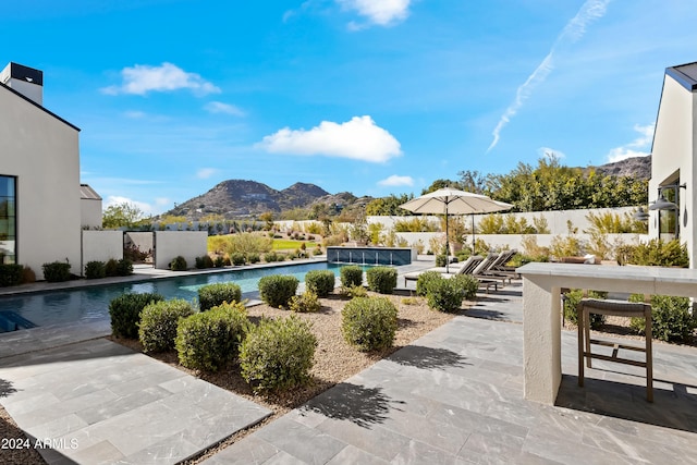 view of swimming pool with a patio area and a mountain view