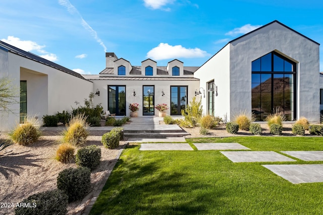 rear view of house featuring a yard