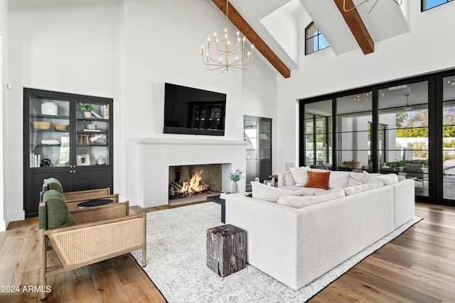 living room with beamed ceiling, an inviting chandelier, high vaulted ceiling, and hardwood / wood-style flooring