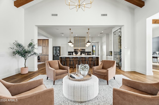 living room with hardwood / wood-style flooring, a notable chandelier, beamed ceiling, and high vaulted ceiling