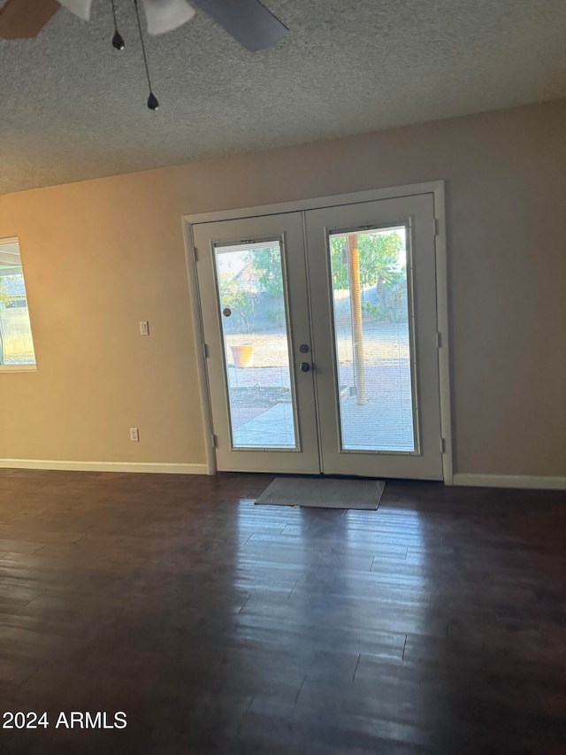 entryway with ceiling fan, french doors, dark wood-type flooring, and a textured ceiling