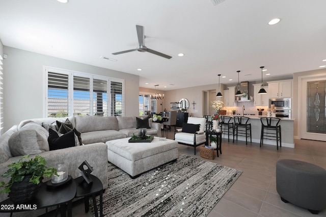 living room with a wealth of natural light, tile patterned flooring, visible vents, and recessed lighting