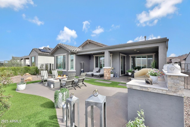 back of house with a patio area, fence, exterior kitchen, and stucco siding