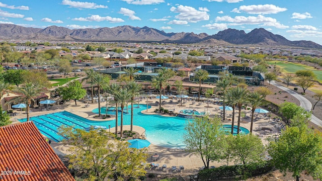 community pool with a patio area, a residential view, and a mountain view