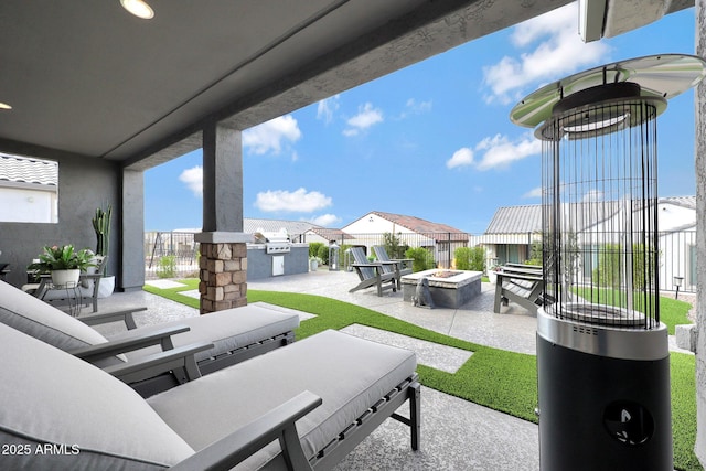 view of patio / terrace featuring an outdoor fire pit, fence, and a residential view