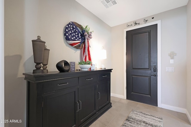 foyer entrance with light tile patterned floors, visible vents, and baseboards