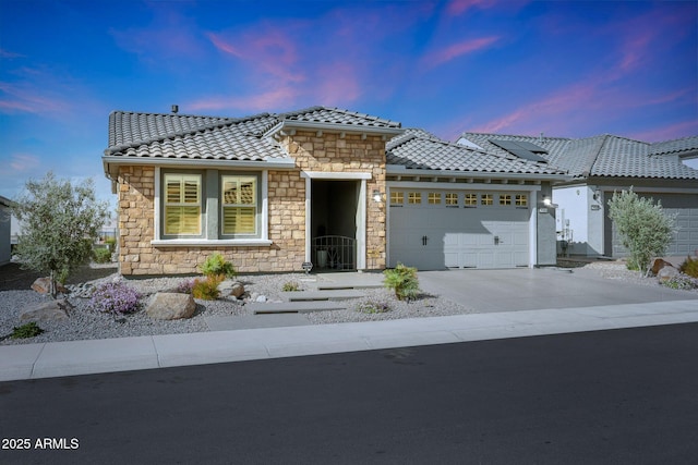 view of front of house with a garage, driveway, and a tile roof