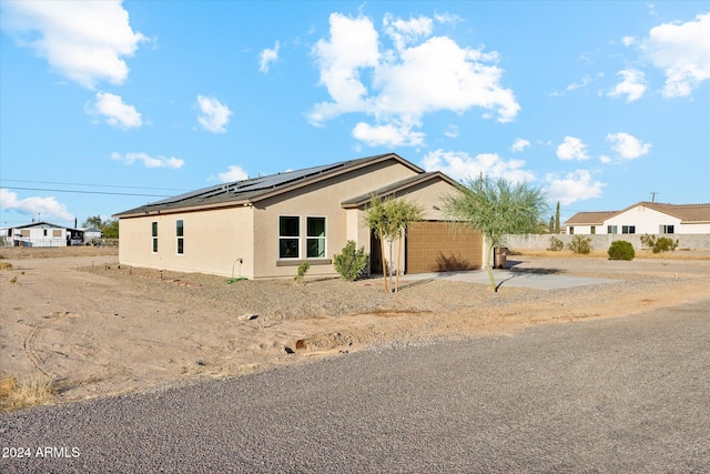 view of front facade with solar panels and a garage