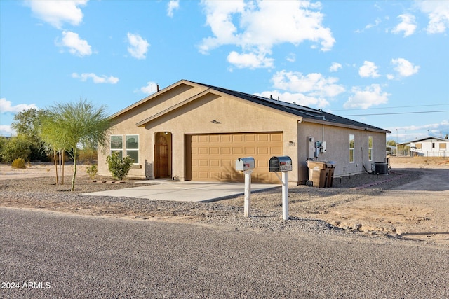 ranch-style home with central air condition unit and a garage