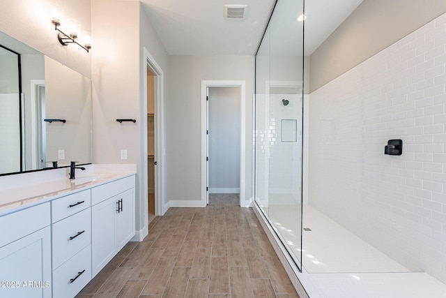 bathroom featuring vanity and tiled shower