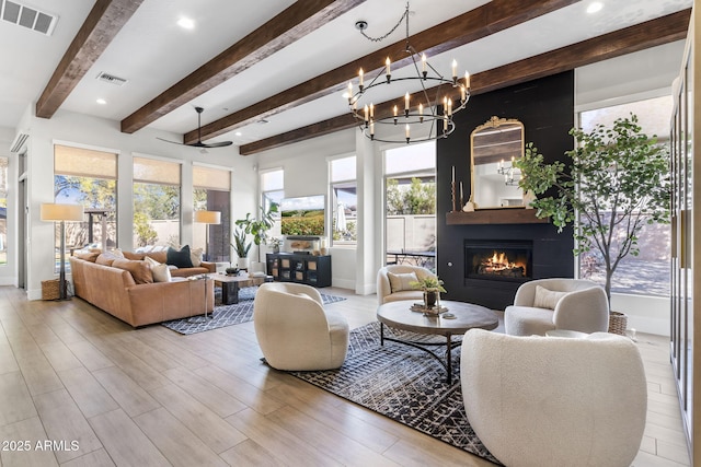 living room with a large fireplace, baseboards, visible vents, and light wood finished floors