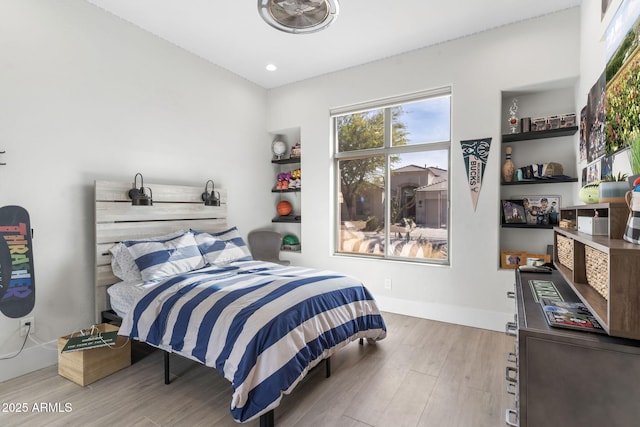 bedroom featuring light wood finished floors and baseboards