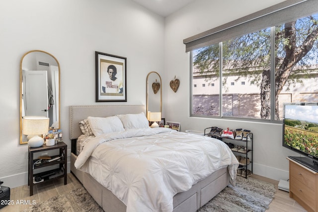 bedroom featuring light wood-type flooring, visible vents, and baseboards