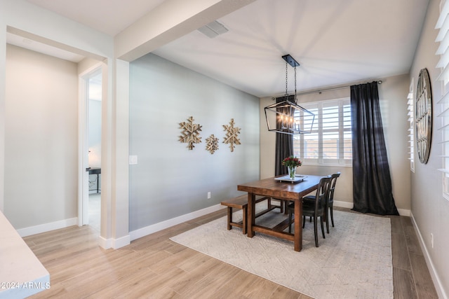 dining room featuring a notable chandelier and light wood-type flooring