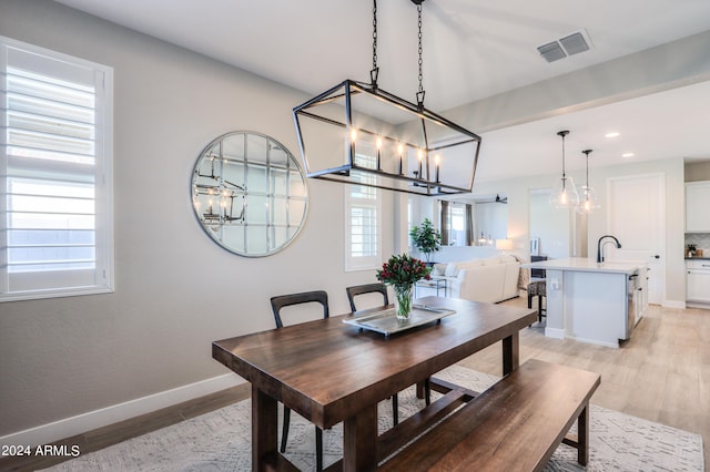 dining room featuring light hardwood / wood-style floors and a notable chandelier