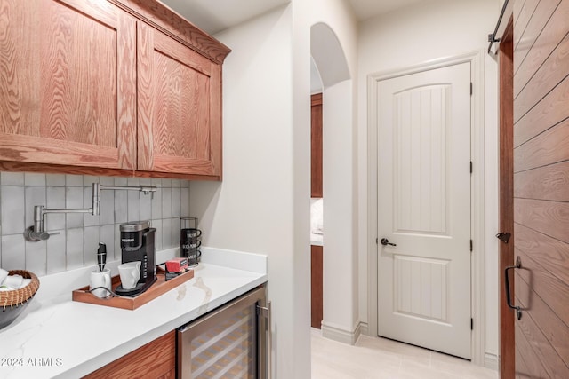 bar featuring light tile patterned flooring, wine cooler, and tasteful backsplash