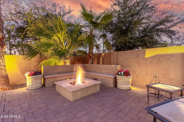 patio terrace at dusk featuring a fire pit