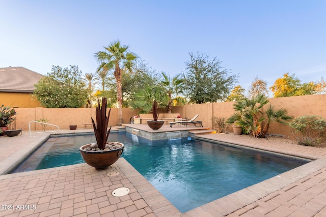 view of swimming pool with a fire pit and a patio