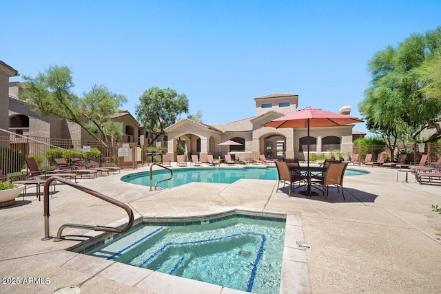 pool featuring fence, a patio, and a hot tub