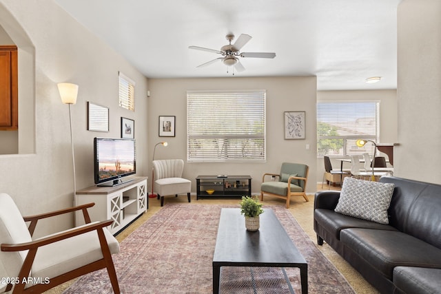 living room with arched walkways and a ceiling fan