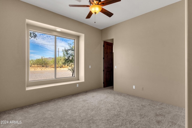 carpeted empty room featuring ceiling fan