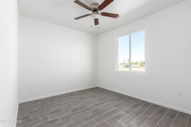 empty room featuring ceiling fan, dark wood-style flooring, and baseboards