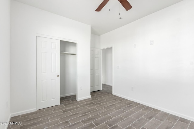 unfurnished bedroom with ceiling fan, baseboards, dark wood-style flooring, and a closet