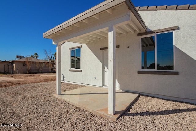 doorway to property featuring a patio area and stucco siding