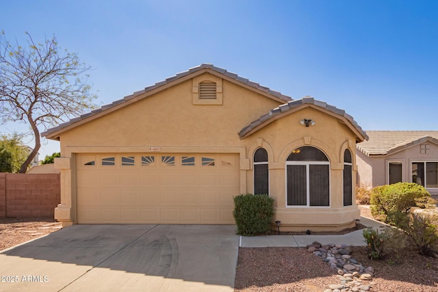 mediterranean / spanish-style house featuring stucco siding, concrete driveway, and an attached garage