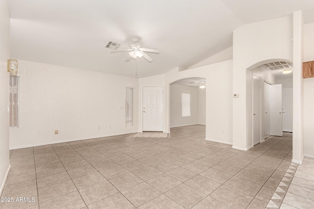 empty room with arched walkways, visible vents, lofted ceiling, and ceiling fan