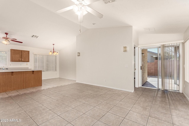 unfurnished living room with lofted ceiling, a healthy amount of sunlight, and ceiling fan with notable chandelier