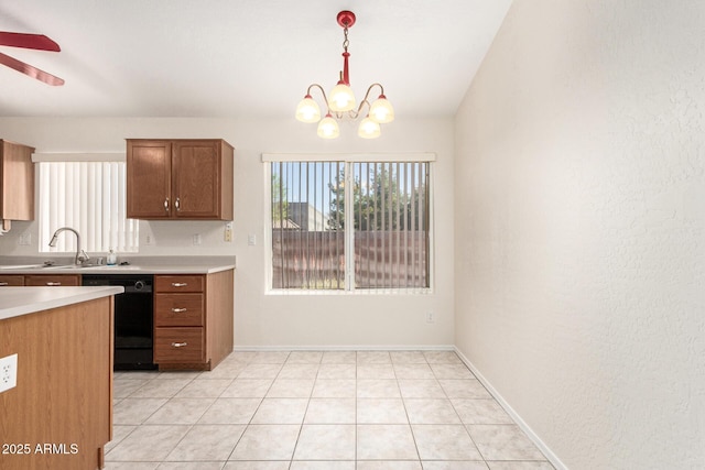 kitchen featuring a sink, hanging light fixtures, light countertops, black dishwasher, and ceiling fan with notable chandelier