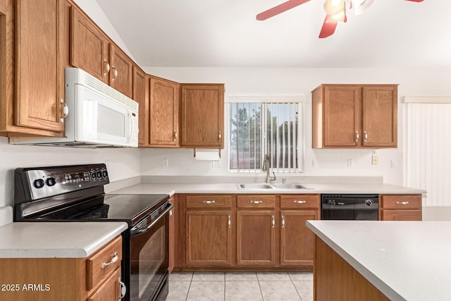 kitchen with a sink, brown cabinets, black appliances, and light tile patterned floors