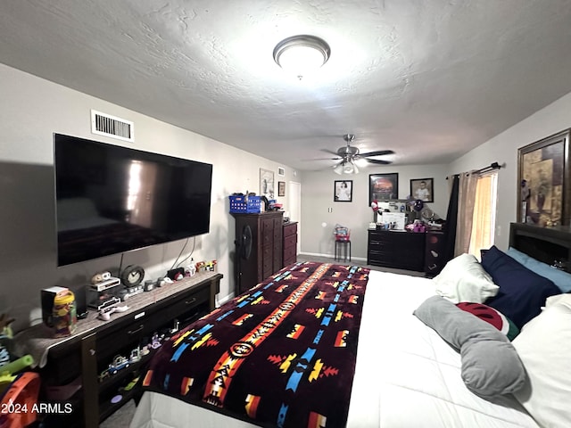 bedroom featuring ceiling fan and a textured ceiling