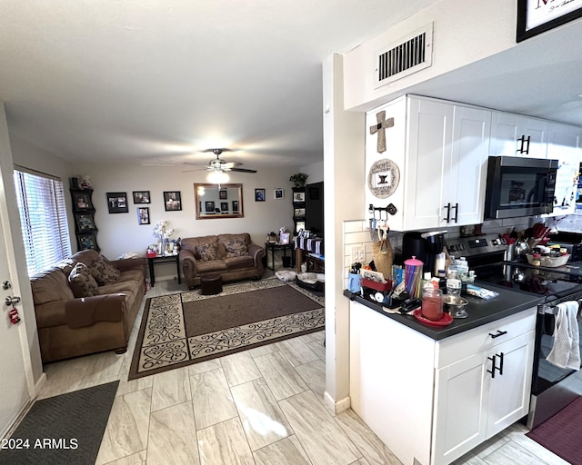 kitchen with white cabinets, stainless steel appliances, tasteful backsplash, and ceiling fan