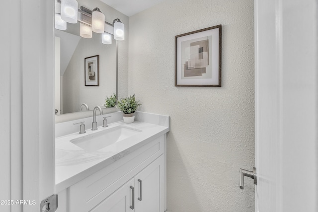 bathroom with vanity and a textured wall