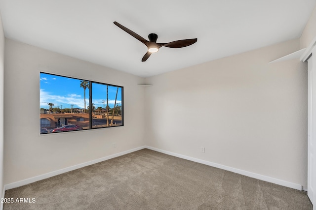 spare room featuring baseboards, carpet floors, and ceiling fan