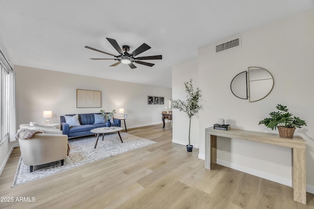 living area with a ceiling fan, light wood-style floors, visible vents, and baseboards