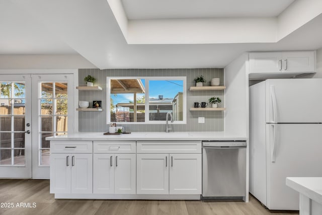 kitchen with open shelves, dishwasher, a sink, and freestanding refrigerator