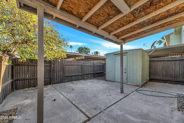 view of patio with an outdoor structure, a storage unit, and a fenced backyard