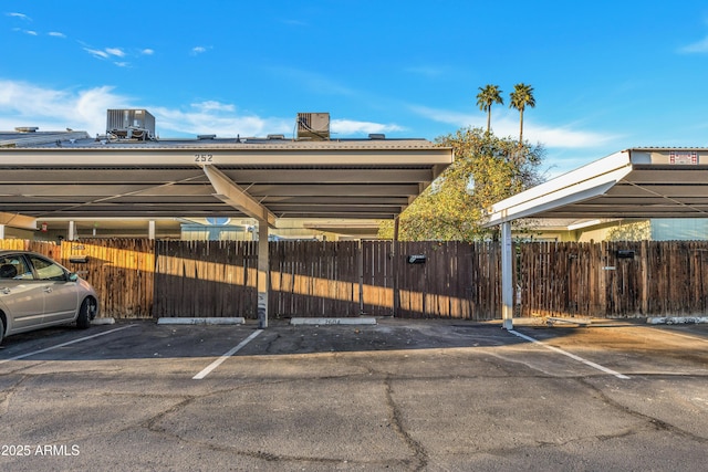 covered parking lot featuring fence