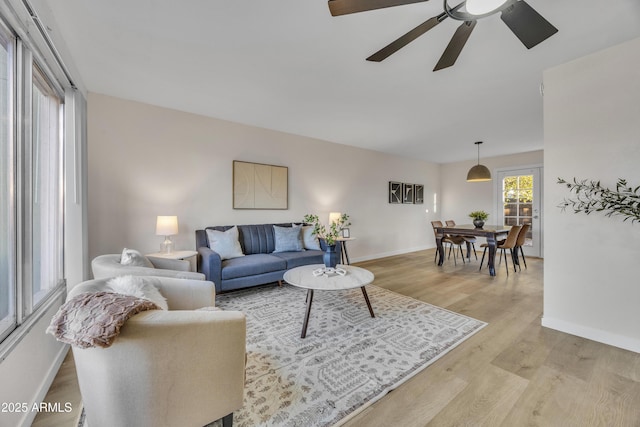 living area featuring light wood-style floors and baseboards