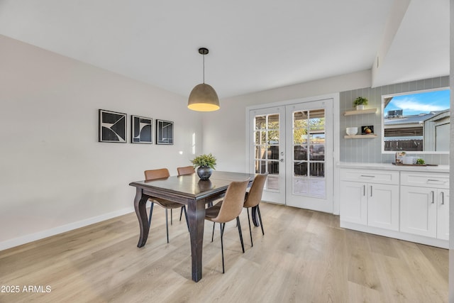 dining room with french doors, baseboards, and light wood finished floors