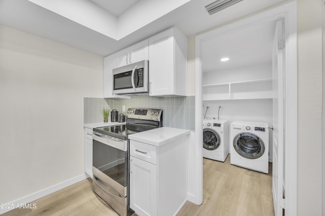 kitchen featuring independent washer and dryer, tasteful backsplash, appliances with stainless steel finishes, and light wood finished floors