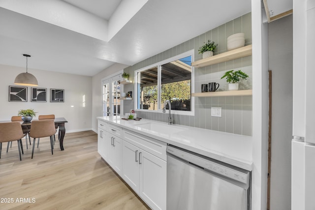 kitchen featuring dishwasher, open shelves, backsplash, and a sink